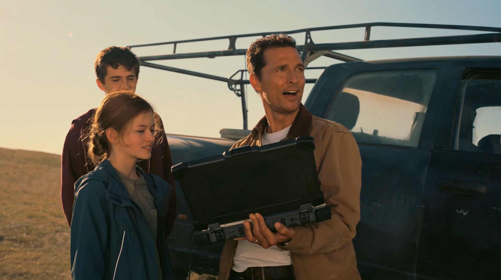 Cooper and Murph controlling the drone as Tom watches them.